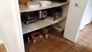 The bottom shelf, now with appliances. The floor has some cans